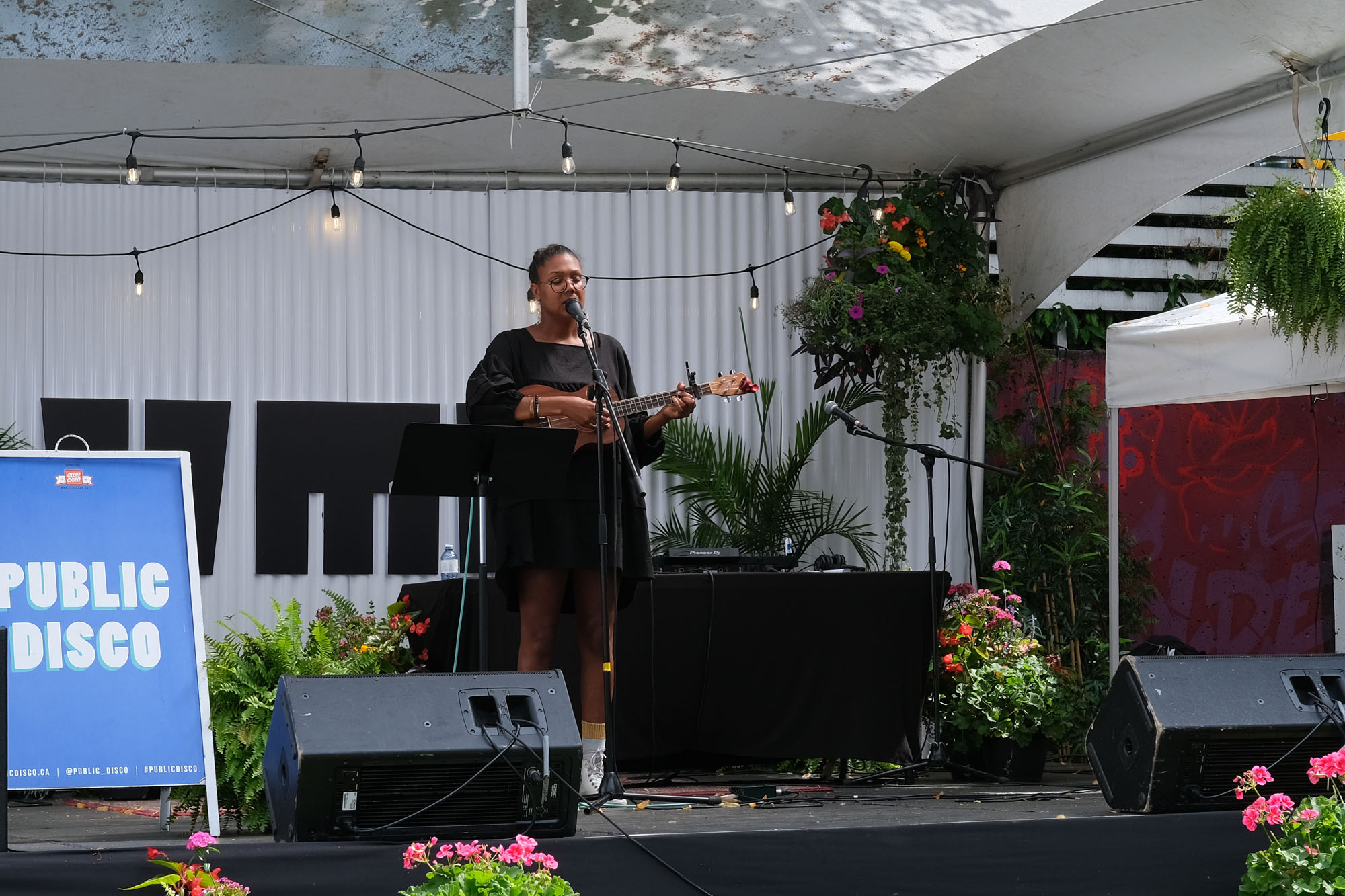 Vancouver musician Desirée Dawson plays a ukulele and sings on an outdoor stage.