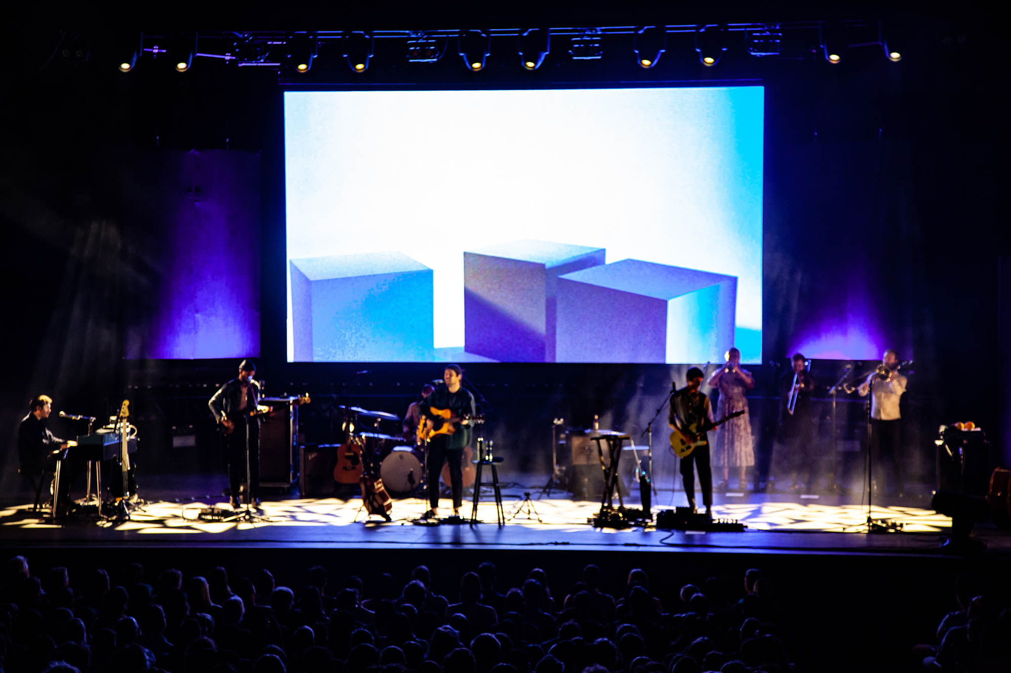 Fleet Foxes and backing brass band are bathed in white light at the Queen Elizabeth Theatre