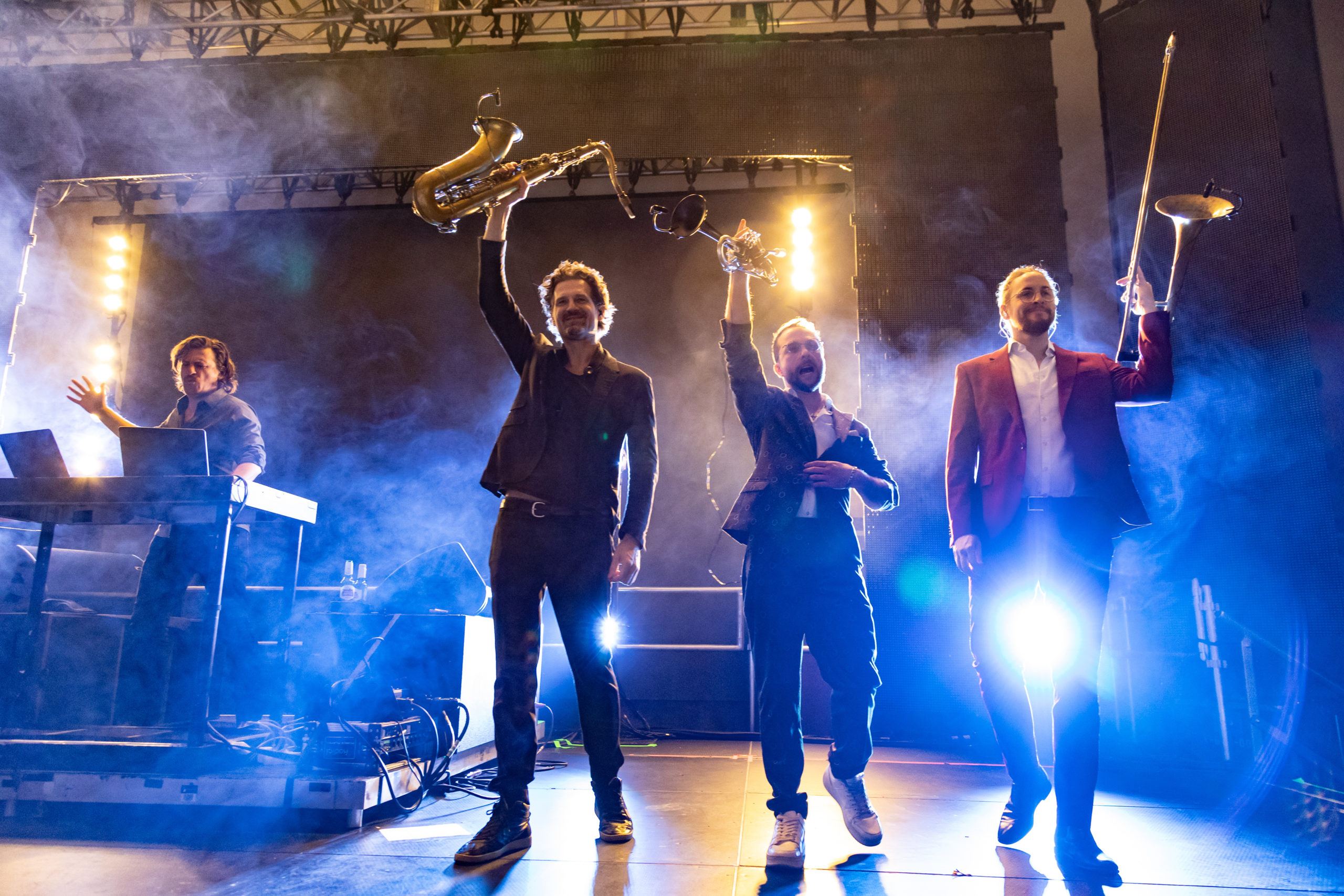 Parov Stelar takes to the stage with his brass band backlit and waving their instruments