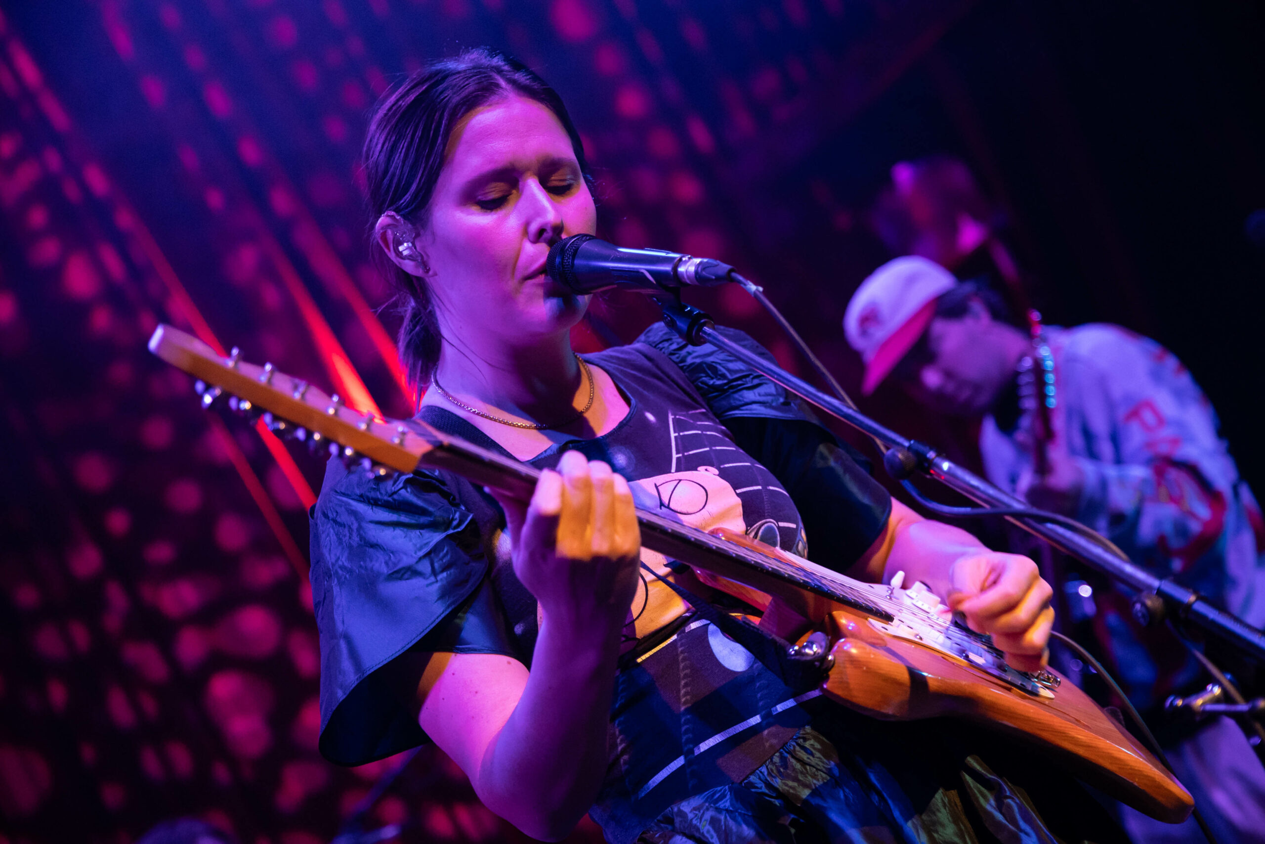 Middle Kids are on the stage of the Fox Cabaret bathed in purple and pink lights, playing guitar