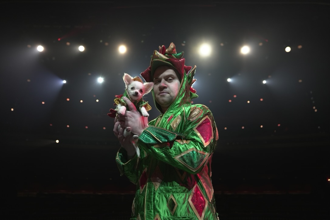 Piff dressed up in his dragon costume and Fourtune backlit by stage lights