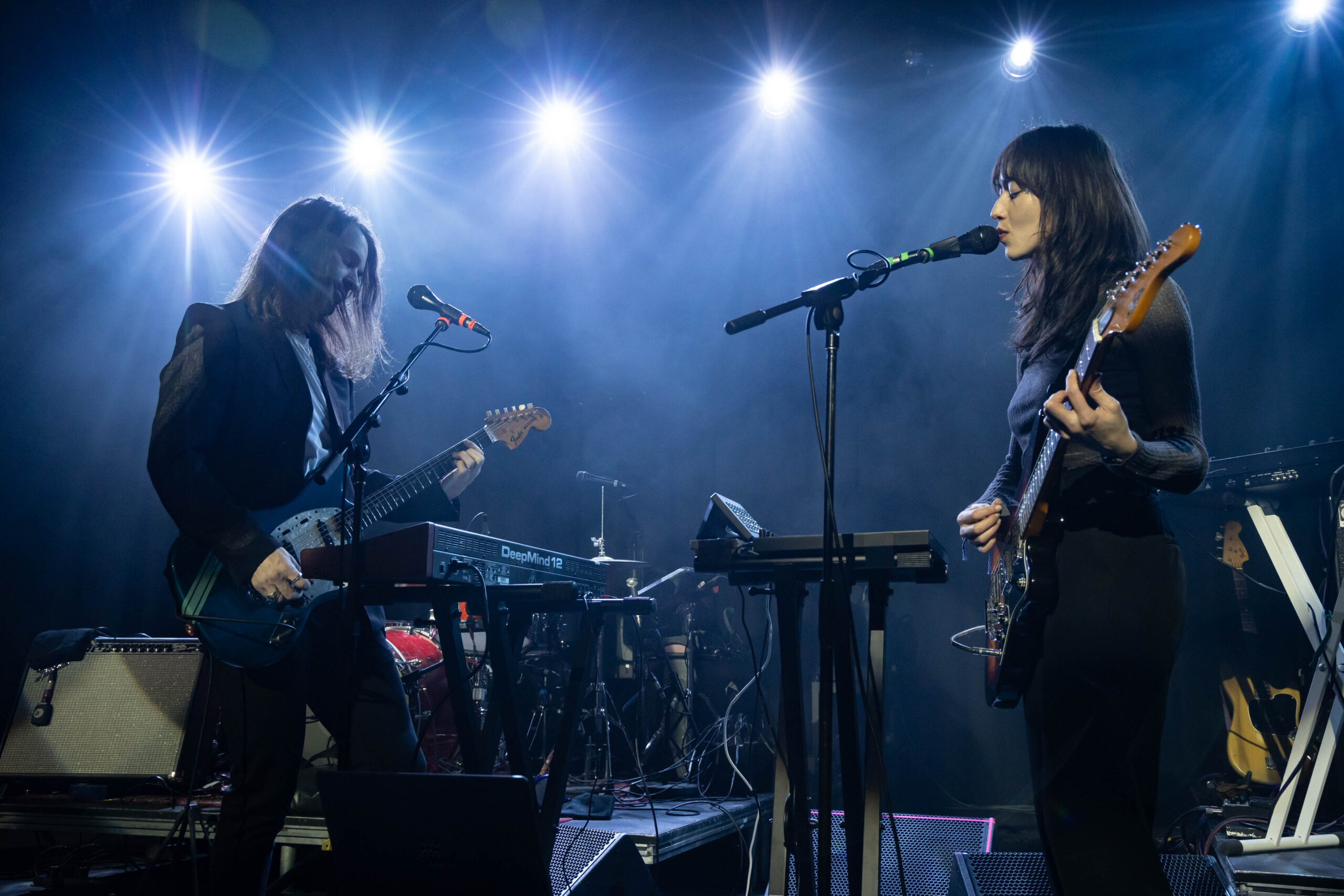 Two of the band members from Fazerdaze are back lit by starry white light at the Commodore Ballroom