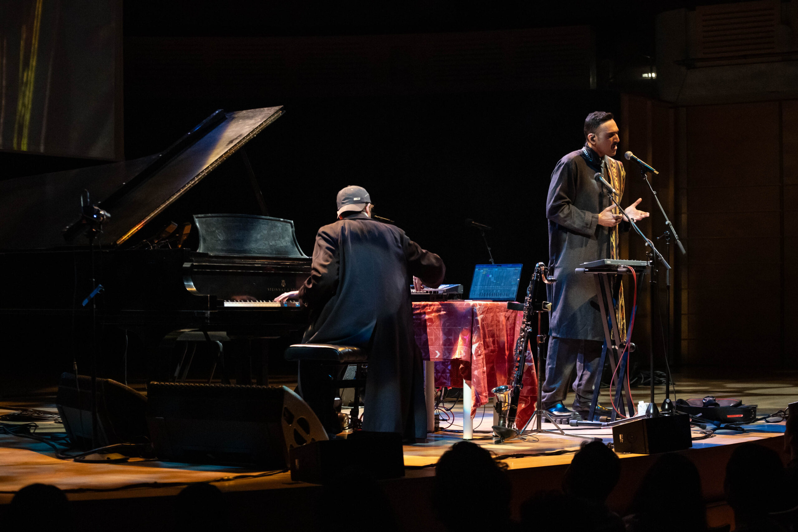 Nicolás Jaar and Ali Sethi are on stage at the Chan Centre with Jaar at a piano and Ali at the microphone.